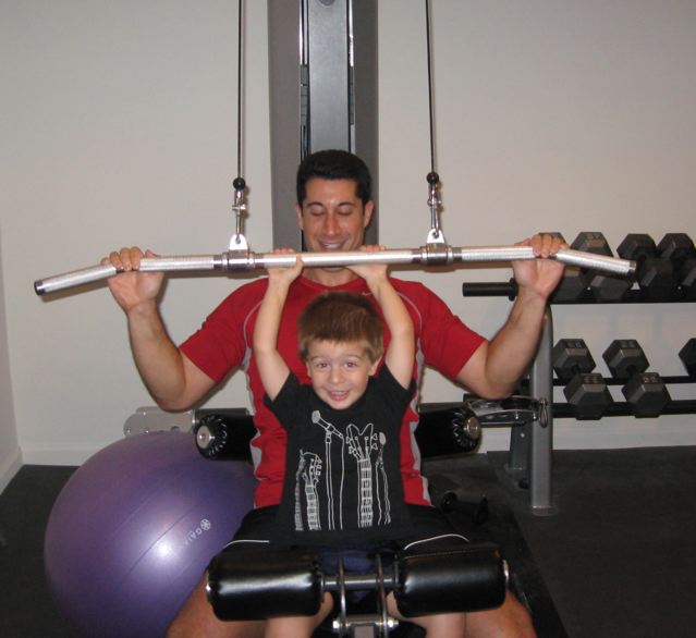 Kyle shows Daddy how to do the lat pulldown.