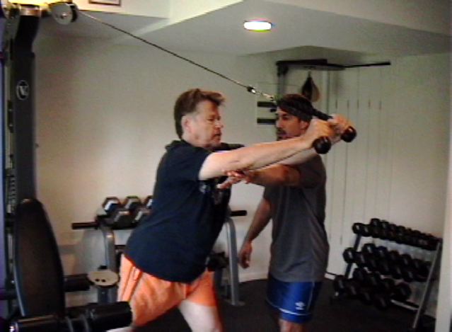 Eric helps client Ed with rope tricep extension.